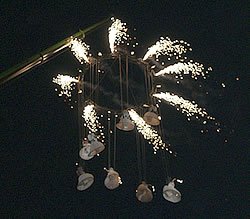 The angels suspended from a ring hanging from the crane release white fireworks